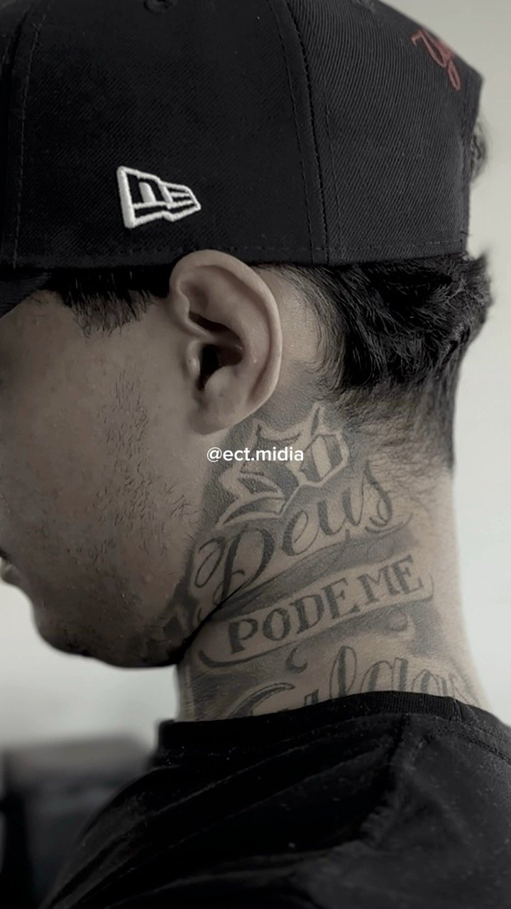 Barbeiro de boné com tatuagem no pescoço