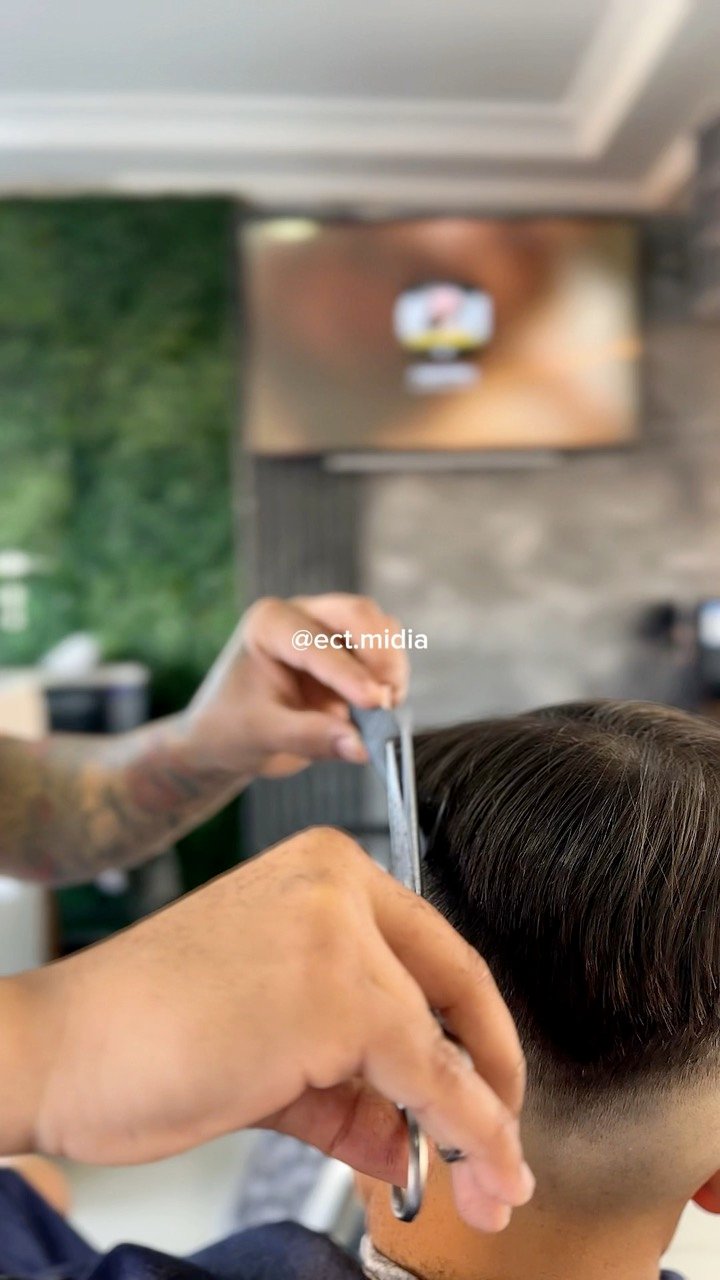 Barbeiro cortando cabelo com tesoura e pente